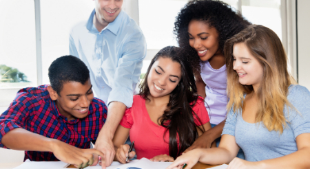 Students gathered around a table working together 